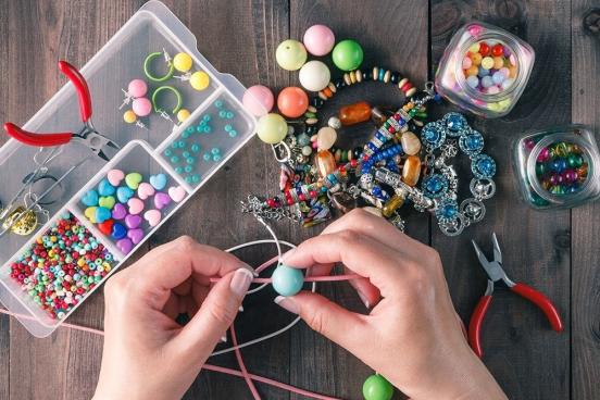 Someone making jewelery using twine and beads