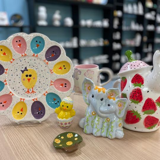 A plate with chics on it, an eleaphant painted, a tiny mushroom tray, a painted pink and purple mug, and a strawberry tea pot.