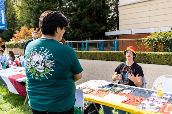 two student speaking across a table at an event