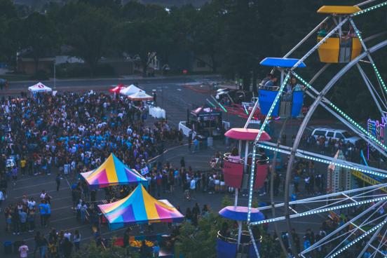 Ferris wheel and carnival tents with people