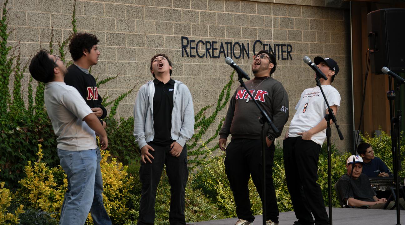 Fraternity students singing on stage at seawolf plaza