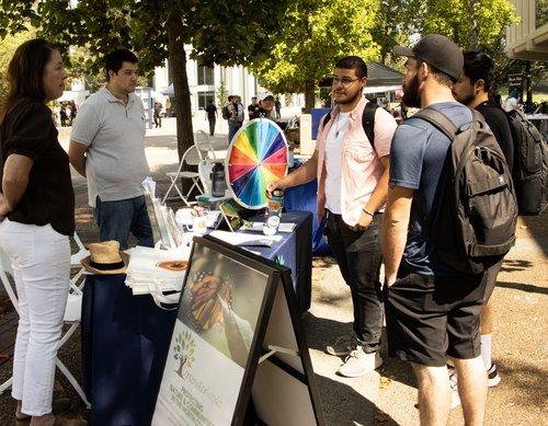 student standing around a table with a spinning wheel