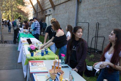 student standing behind tables at an outdoor resource event