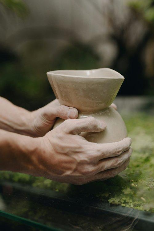 hands shaping a clay vase