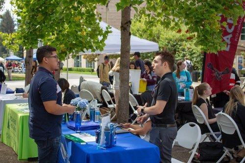 two people speaking at an outdoor resource fair event