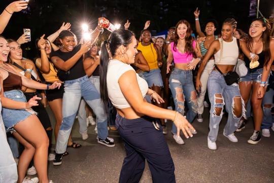 Circle of students cheering to a dancing student