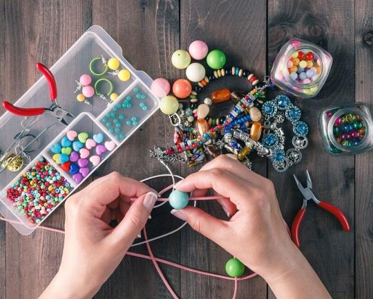 Someone making jewelery using twine and beads