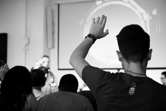 Person raising hand during lecture