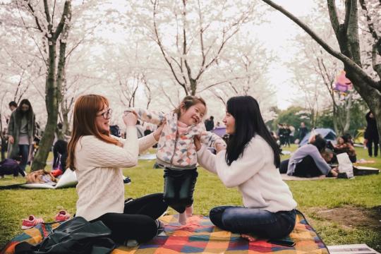 two women having a picnic with a child