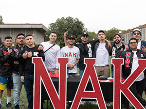 a group of male students in front of a fraternity sign